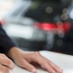 Illustration of a person reviewing a car lease agreement, representing steps to end a lease early without penalties