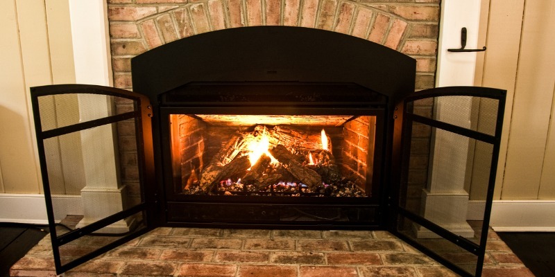 Close-up of realistic ceramic log flames in a high-efficiency natural gas hearth, emphasizing clean burn.