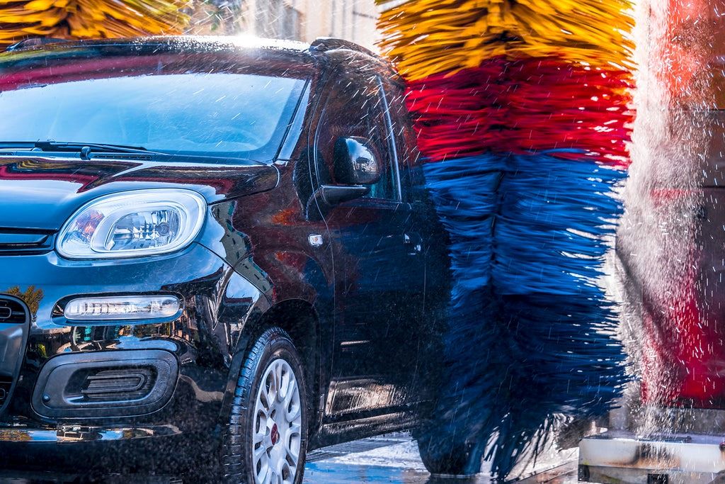 No-contact car wash system in action, using water and cleaning solution without brushes