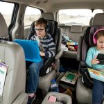 Family using tablet mount in car during Orlando road trip with kids watching movies comfortably