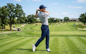 Modern golfer wearing trendy golf gear including a structured cap, leather glove, and spikeless shoes on a sunny fairway