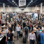 Crowded trade show floor at ASD Market Week Las Vegas with exhibitor booths and retail buyers