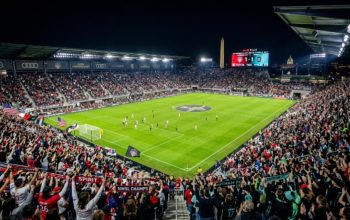 Thousands of soccer fans filling Audi Field in Washington DC for the 2026 NWSL Championship on November 21 under stadium lights at night